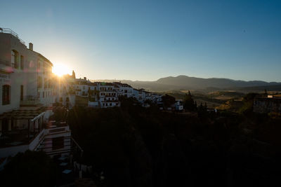 Town by buildings in city against sky during sunset