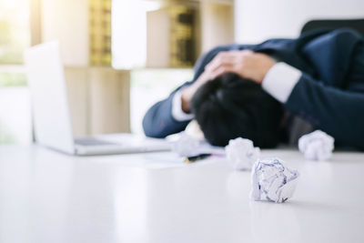 Man sleeping on table with hands behind head