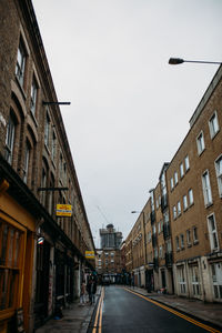 Street amidst buildings against sky in city