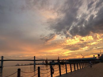 Pier over sea against sky during sunset