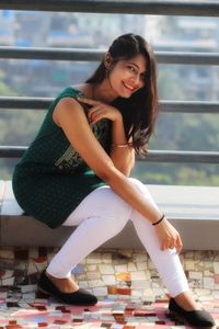 Portrait of smiling young woman sitting outdoors