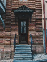 Low angle view of stairs against brick wall