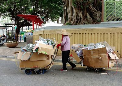 Woman pushing trash carts