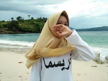 Portrait of senior woman on beach against sky