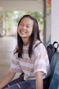 Portrait of a smiling girl sitting outdoors