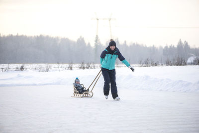 Full length of man with dog on snow