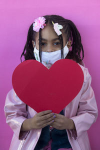 Portrait of woman holding heart shape