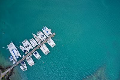 Drone field of view of boats moored in harbour in turquoise blue water praslin seychelles.