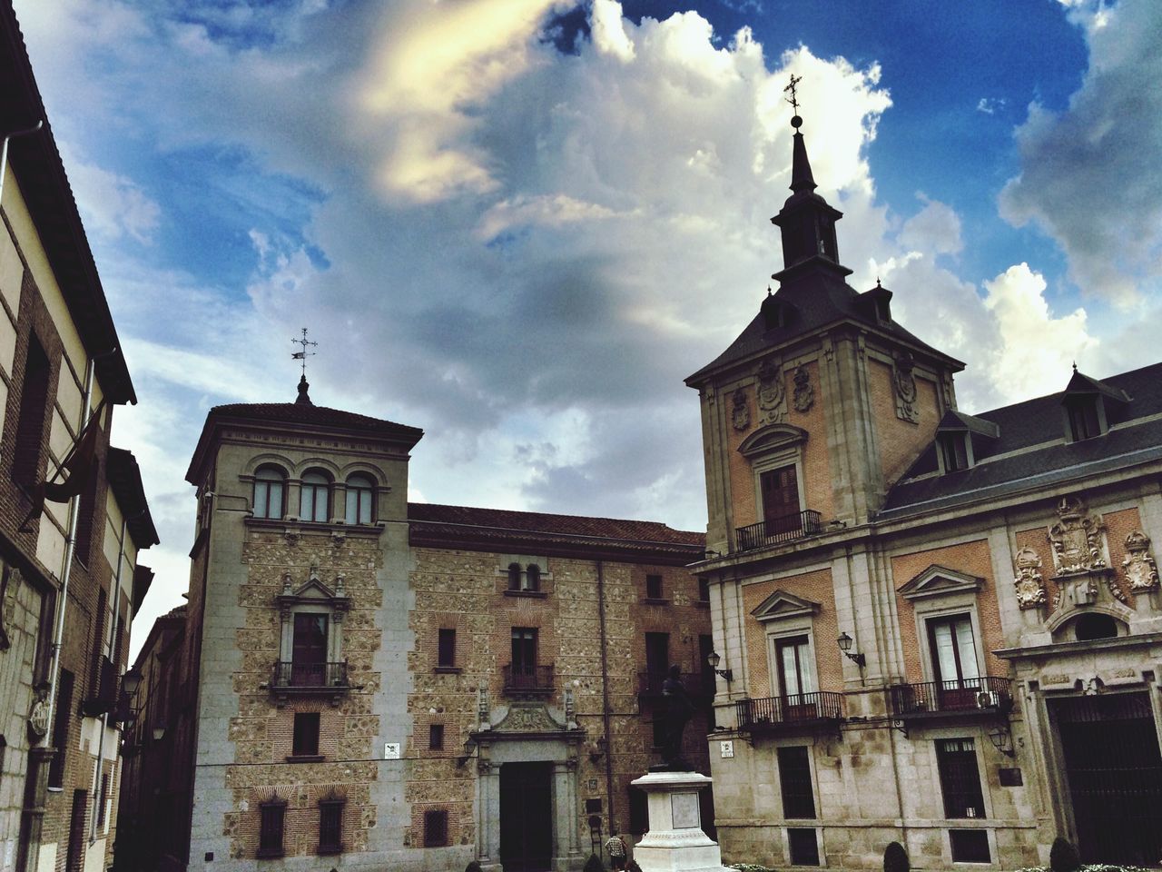 architecture, building exterior, built structure, religion, church, low angle view, sky, place of worship, spirituality, cloud - sky, cloud, cathedral, history, cross, city, day, window, outdoors