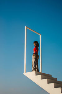 Low angle view of woman standing on sky stair