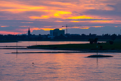 Scenic view of river against sky at sunset