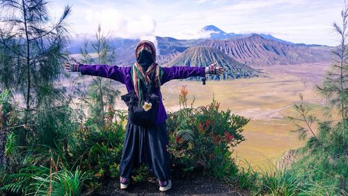 Full length of person standing on mountain against sky