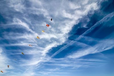 Low angle view of kites flying in sky