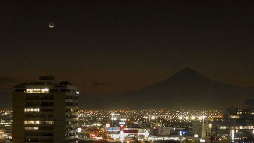 Illuminated cityscape against sky at night