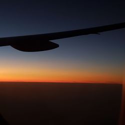 Silhouette airplane against clear sky during sunset