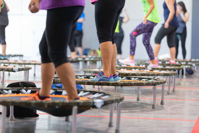 Mini rebounder workout- girls doing fitness exercise in class at gym with music.