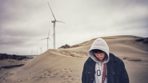 Man wearing hat standing on land against sky