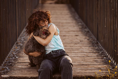 Woman embracing dog on boardwalk