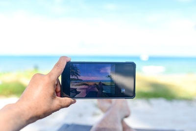 Midsection of man photographing against sky