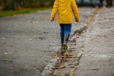 Low section of man walking on road