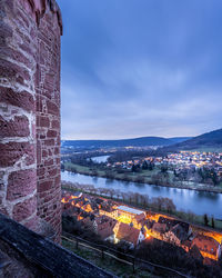 Buildings by river against sky in city