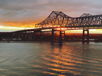 Bridge over sea against sky during sunset