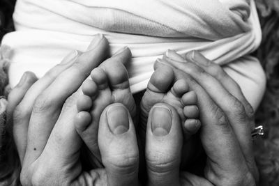 Cropped image of mother touching baby feet