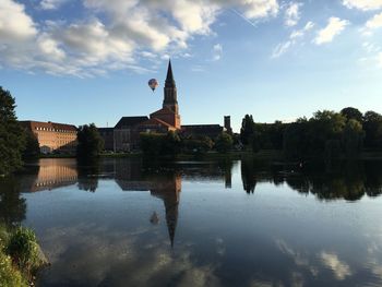 Opera house reflecting on calm lake in city