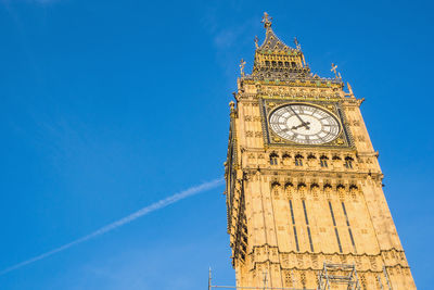 Low angle view of clock tower against blue sky