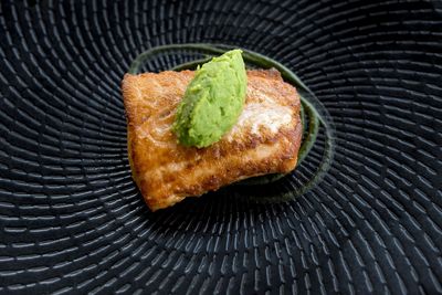 Close-up of grilled salmon in black plate