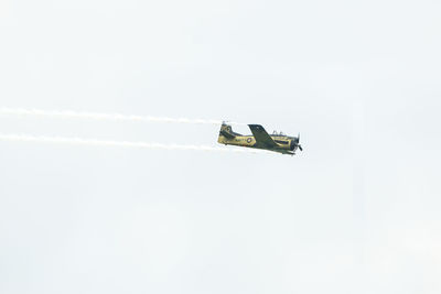 Low angle view of airplane flying against sky