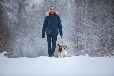 Portrait of man with dog in snow