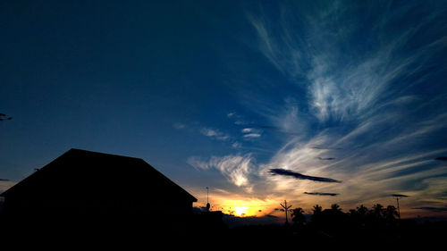 Low angle view of silhouette houses against sky at night