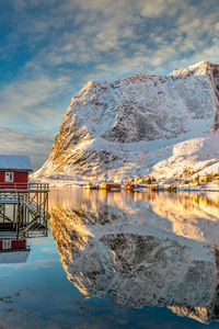 Scenic view of lake by snowcapped mountains against sky