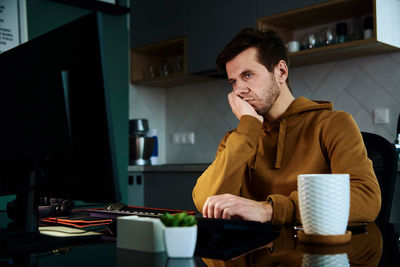 Tired man works late at workplace in the night
