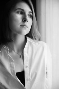 Close-up of young woman looking away at home