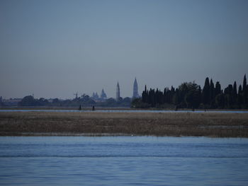 Scenic view of sea by buildings against clear sky