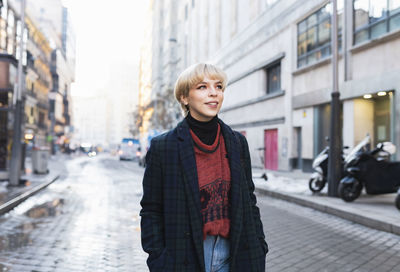 Portrait of woman standing on street in city