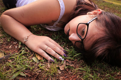 High angle view of young woman resting on field at park