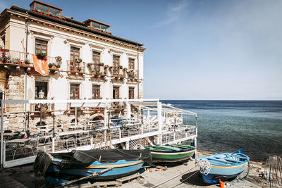 Boats moored on sea against buildings