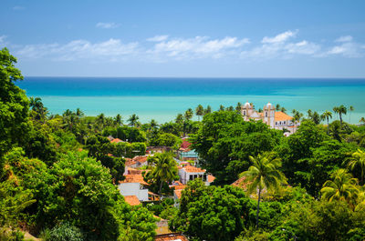 Scenic view of town by sea against sky