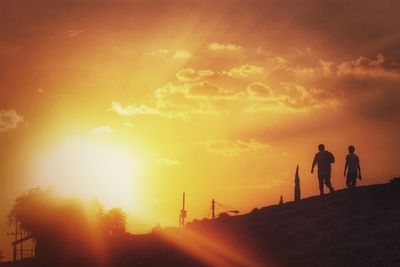 Silhouette people against sky during sunset