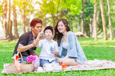 Smiling young woman sitting in park