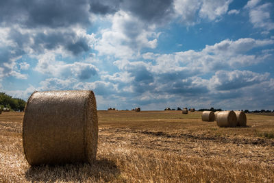 Hay bales on field against sky