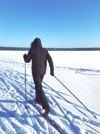 Rear view of man standing on snow covered landscape