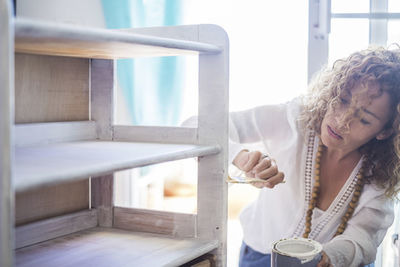 Woman painting furniture at home