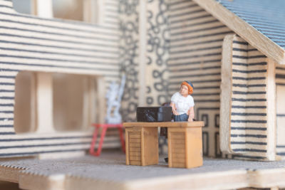 Man sitting on wood against building