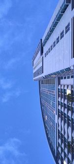 Low angle view of modern building against blue sky