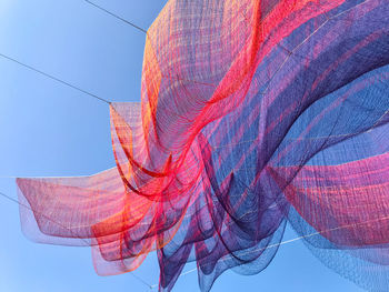 Low angle view of red umbrella against sky