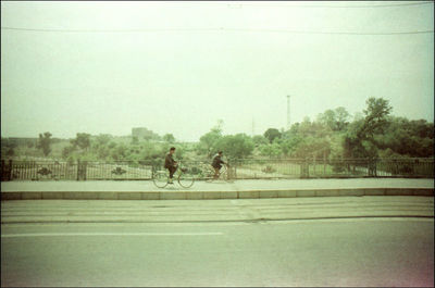 Side view of man riding bicycle on road